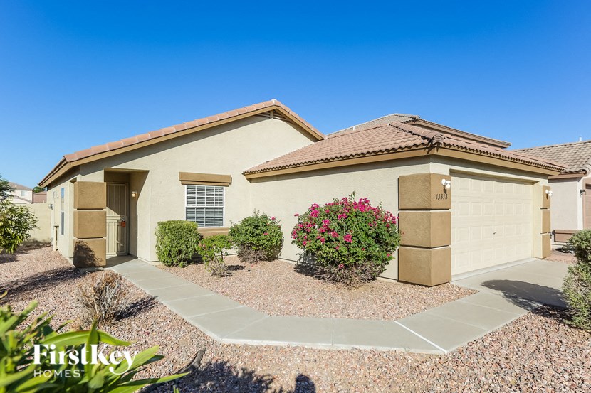 a beige house with a driveway and a garage door