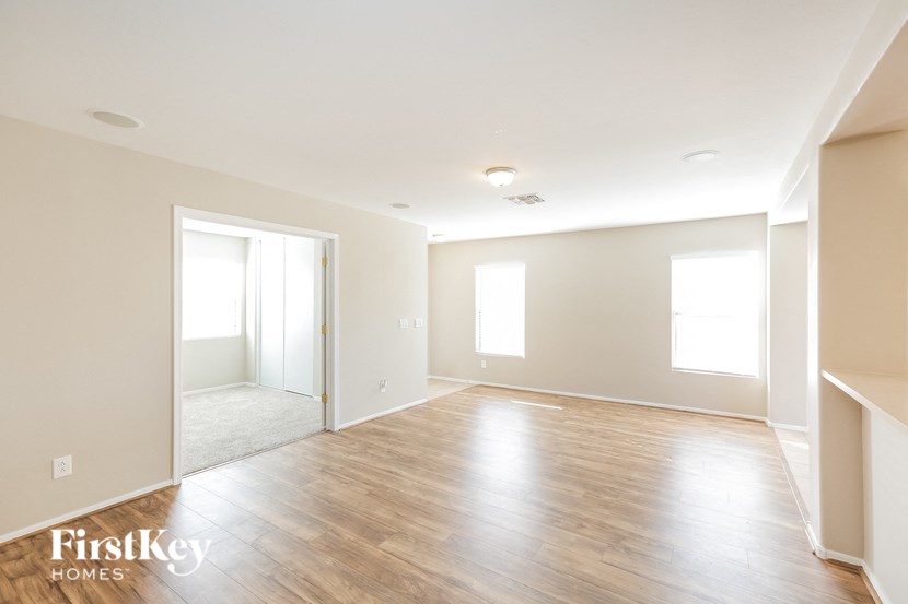 an empty living room with wood floors and white walls