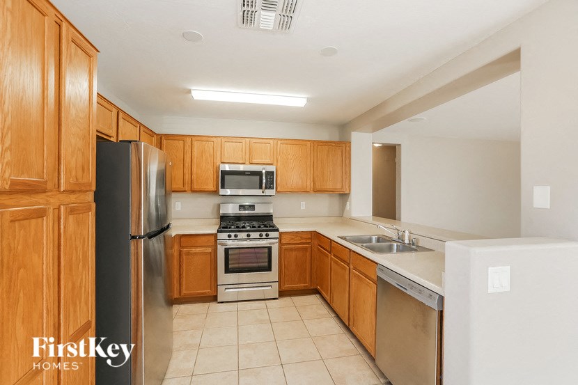 a large kitchen with wooden cabinets and stainless steel appliances