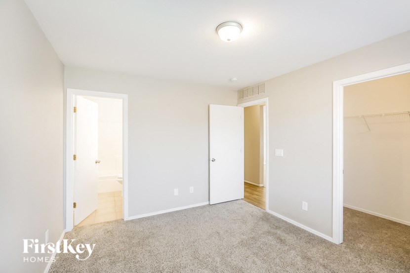 a bedroom with a carpeted floor and a door to a closet