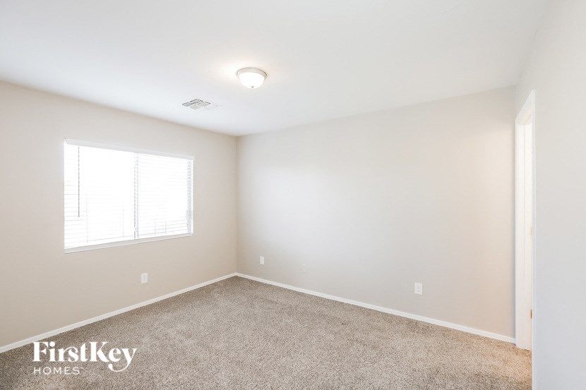 a bedroom with a carpeted floor and a window