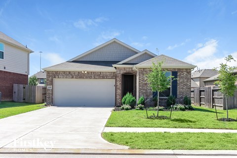 a house with a garage door in front of a lawn