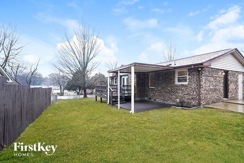 A house with a stone exterior and a wooden fence.