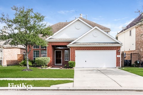 a small brick house with a white garage door
