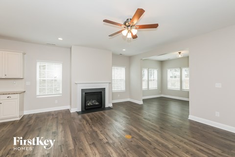 a living room with a fireplace and a ceiling fan