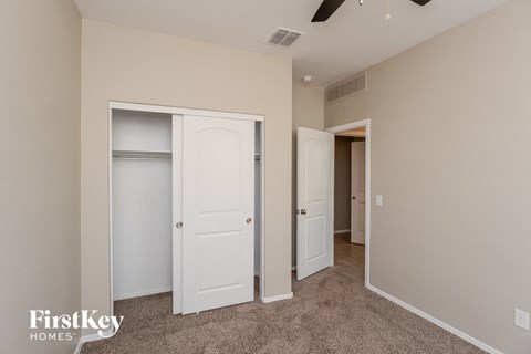 a bedroom with two closets and a hallway with two doors