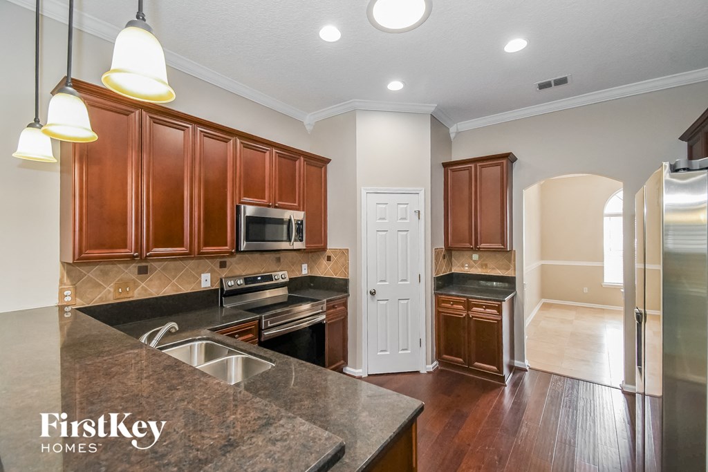 a kitchen with wooden cabinets and stainless steel appliances and granite counter tops