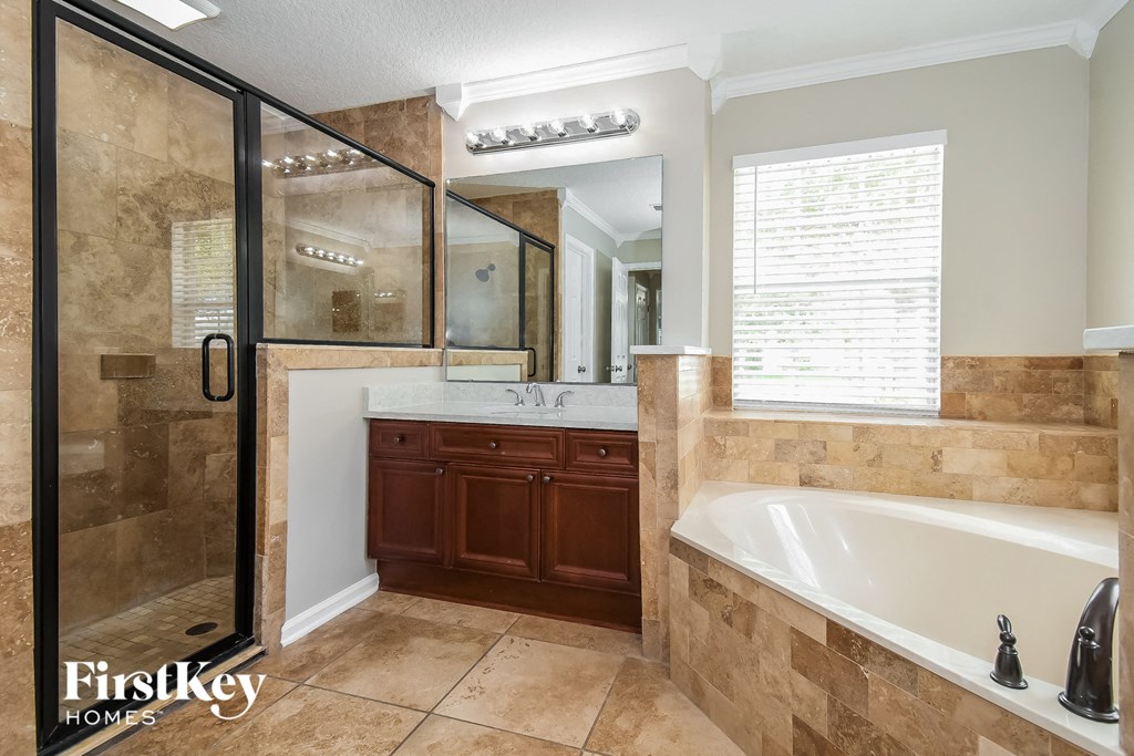a bathroom with a tub and a shower and a sink