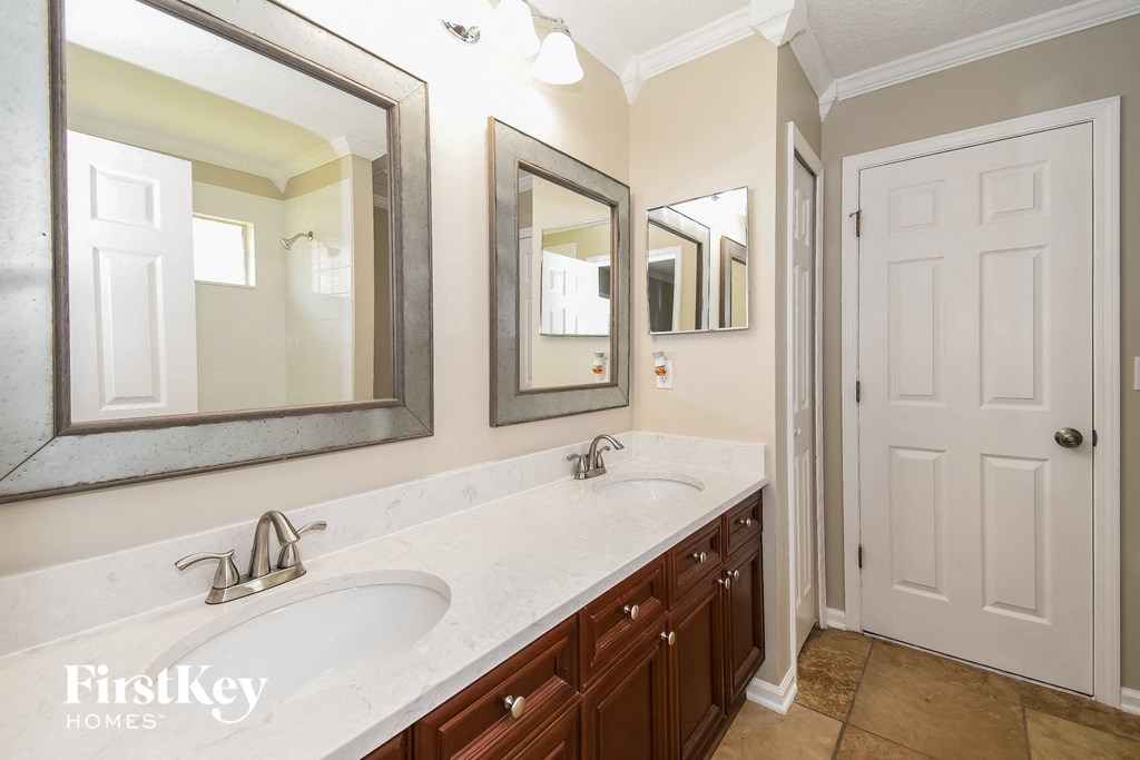 a bathroom with two sinks and two mirrors