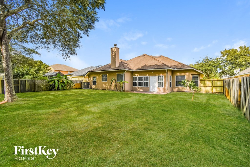 a backyard with a house and a lawn