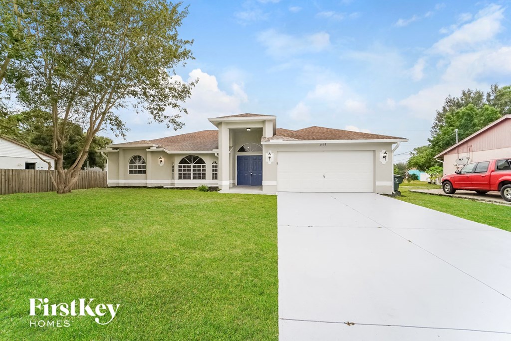 a white house with a lawn and a driveway