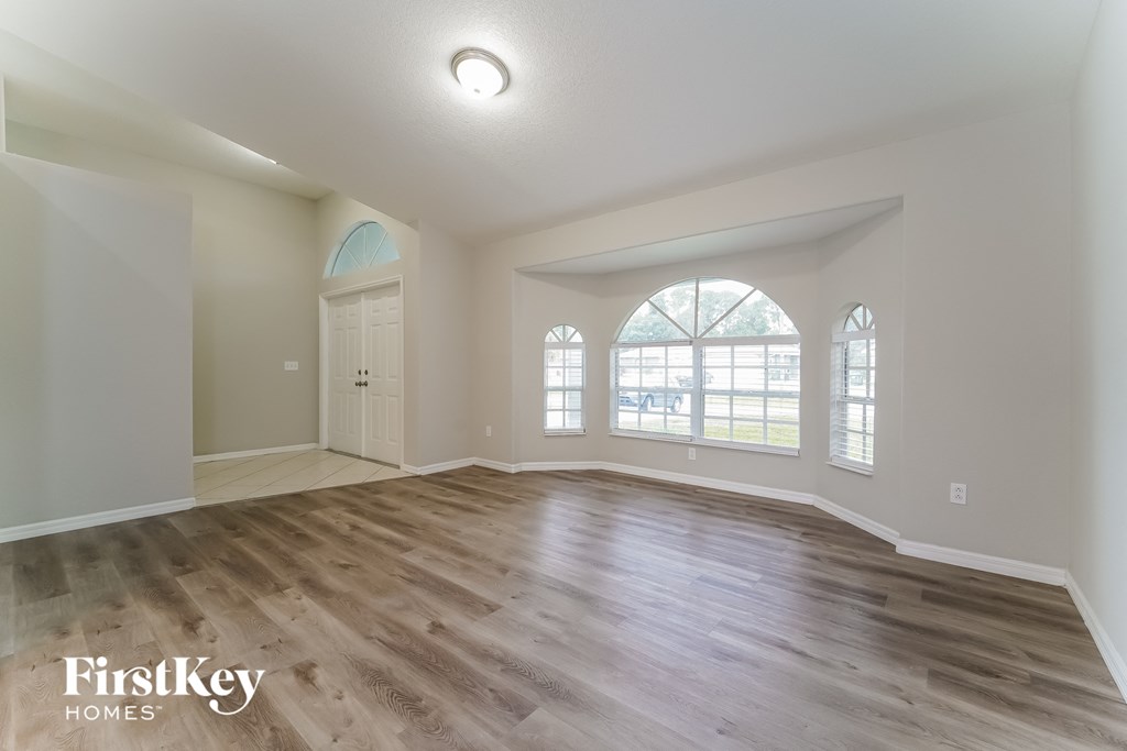 the living room with hardwood floors and a large window