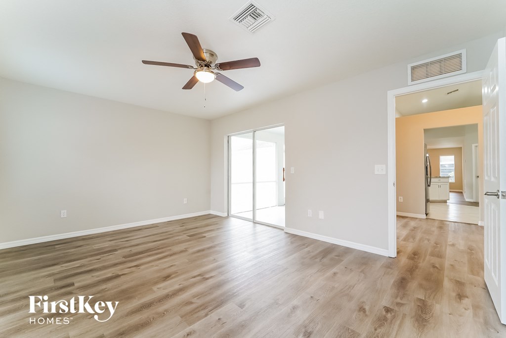 a living room with white walls and a ceiling fan