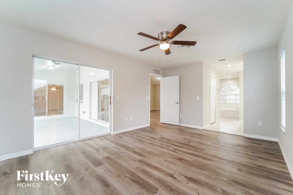 a living room with a ceiling fan and a large mirror