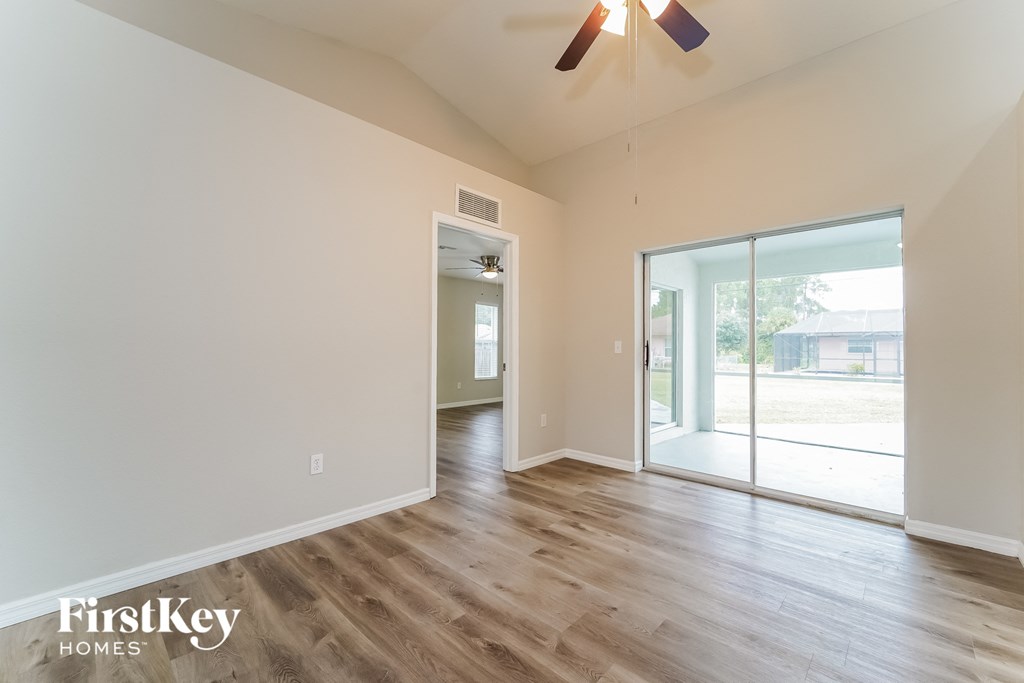 the living room of an empty house with wood floors and a ceiling fan