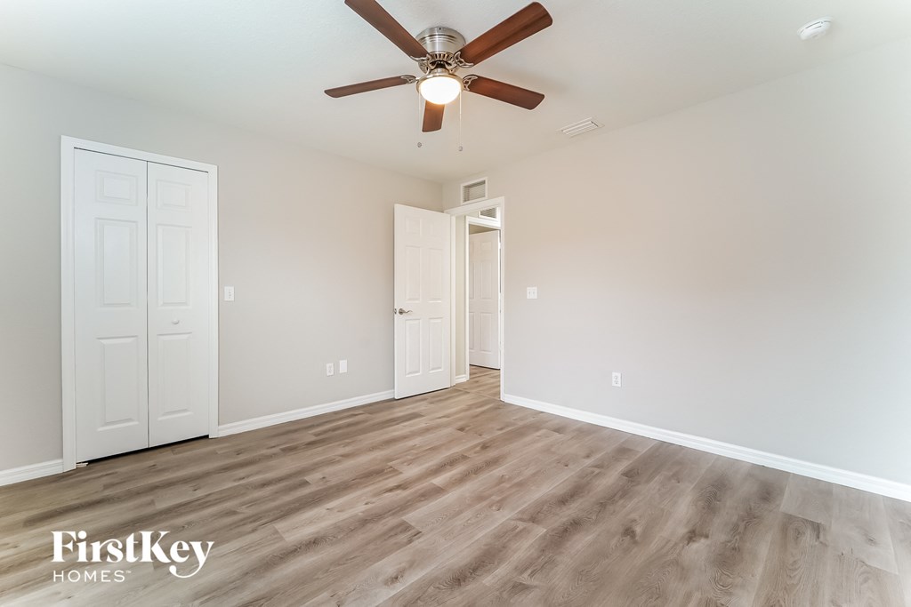 the living room of an empty house with a ceiling fan
