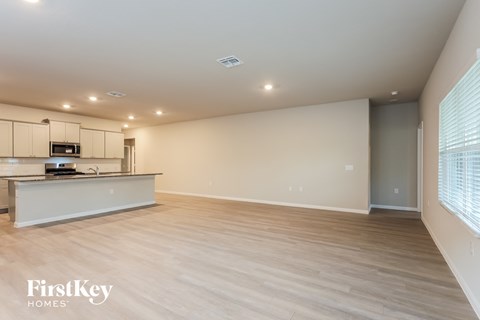A spacious kitchen with wooden flooring and a white countertop.