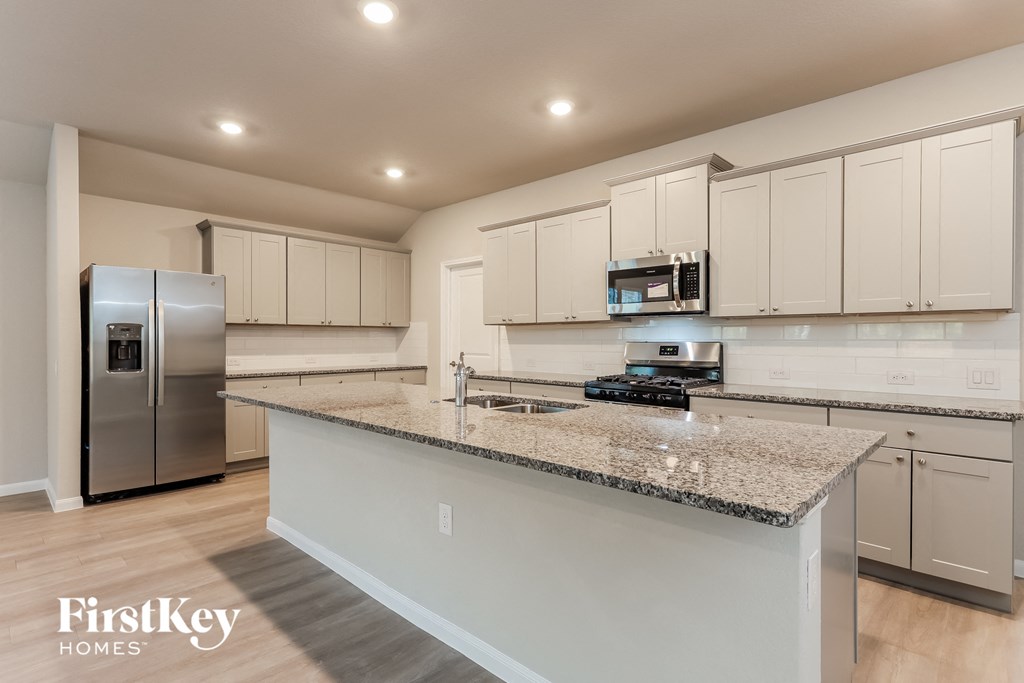 A kitchen with granite countertops and stainless steel appliances.