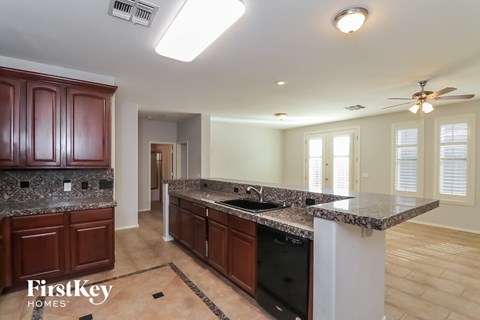 A kitchen with brown cabinets and a marble countertop.