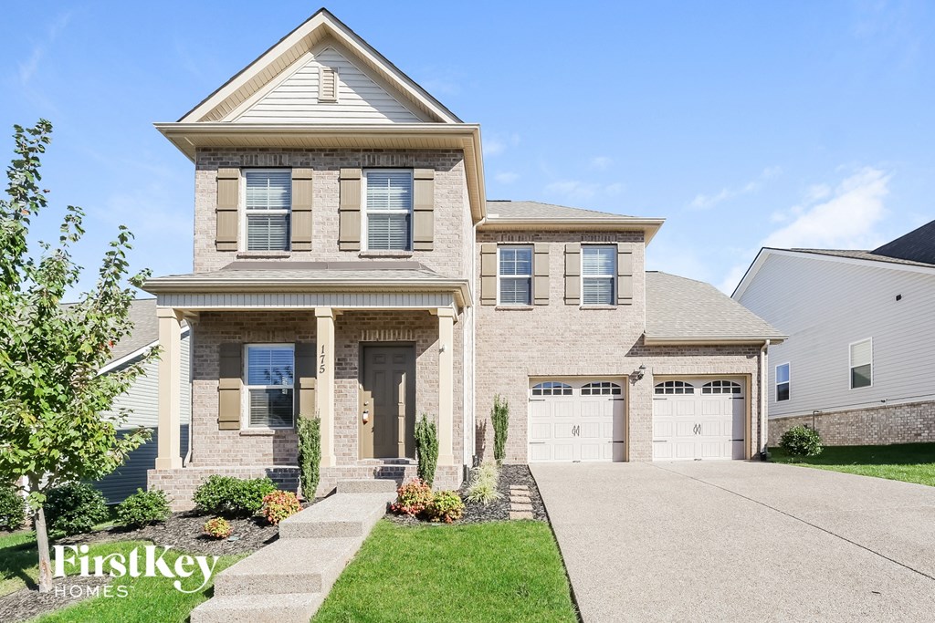 a large brick house with two garage doors
