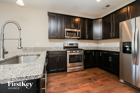 a kitchen with black cabinets and stainless steel appliances and granite counter tops