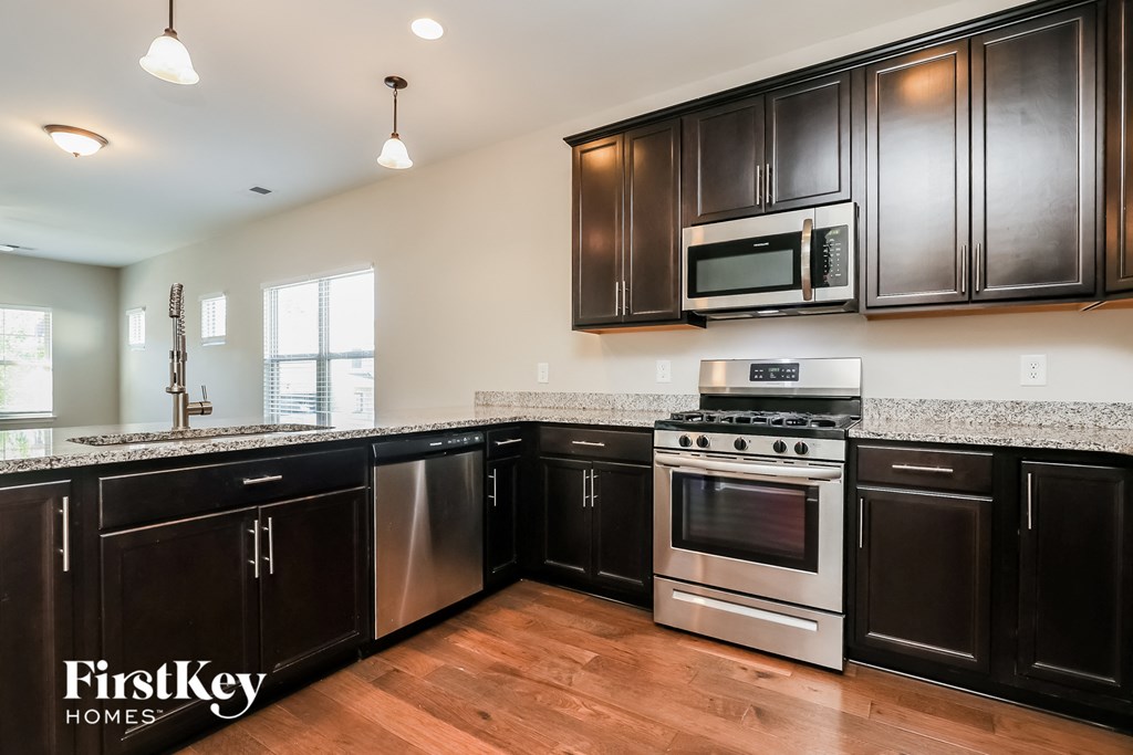a kitchen with black cabinets and stainless steel appliances and granite counter tops