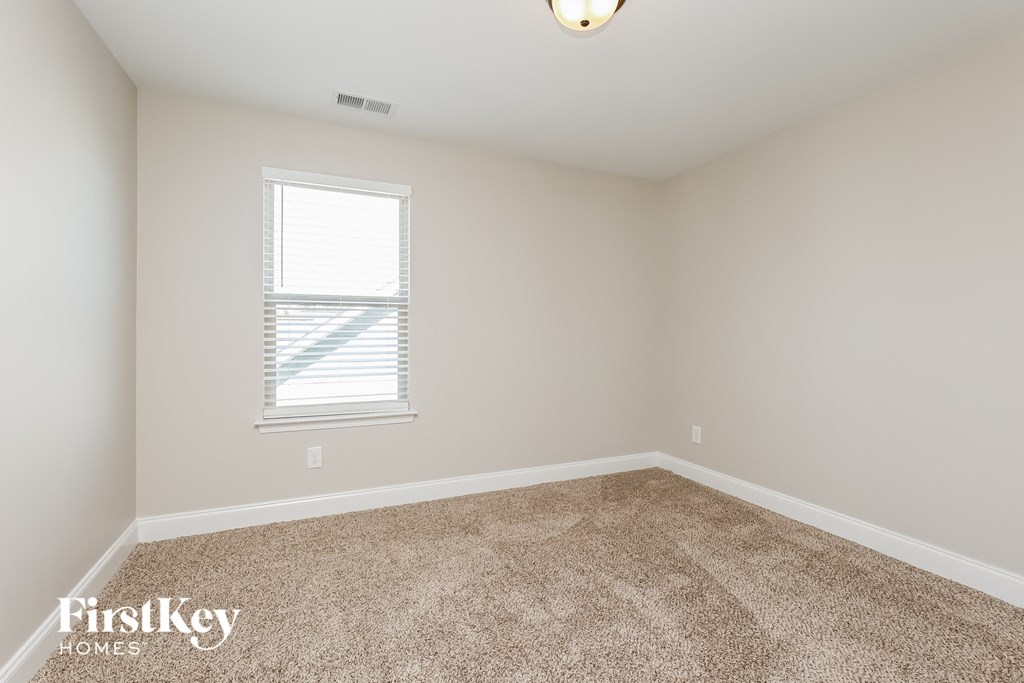 a bedroom with a carpeted floor and a window
