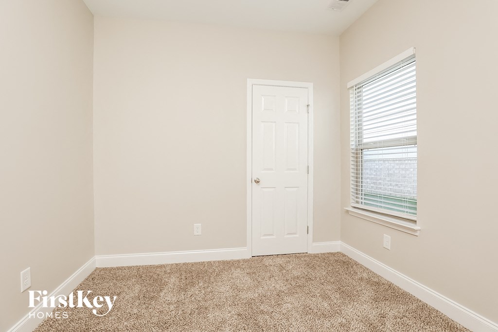 a room with carpet and a door and a window