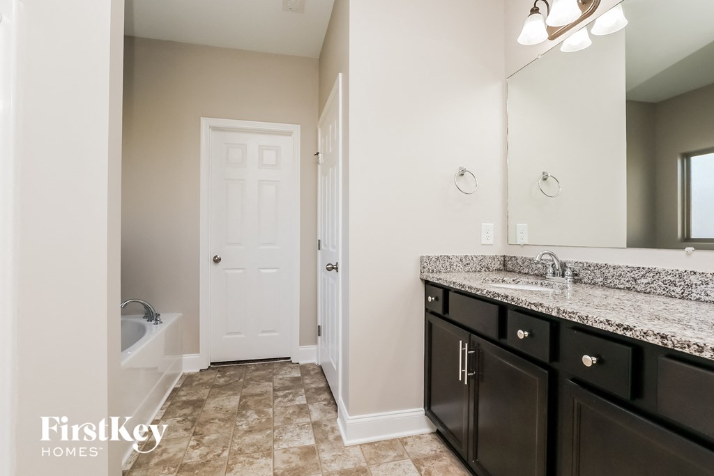a bathroom with a large mirror and a sink and a tub