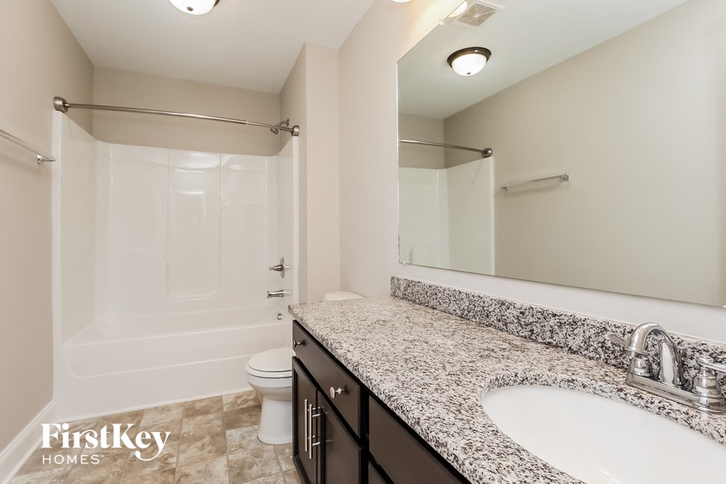a bathroom with a sink and a shower and a toilet
