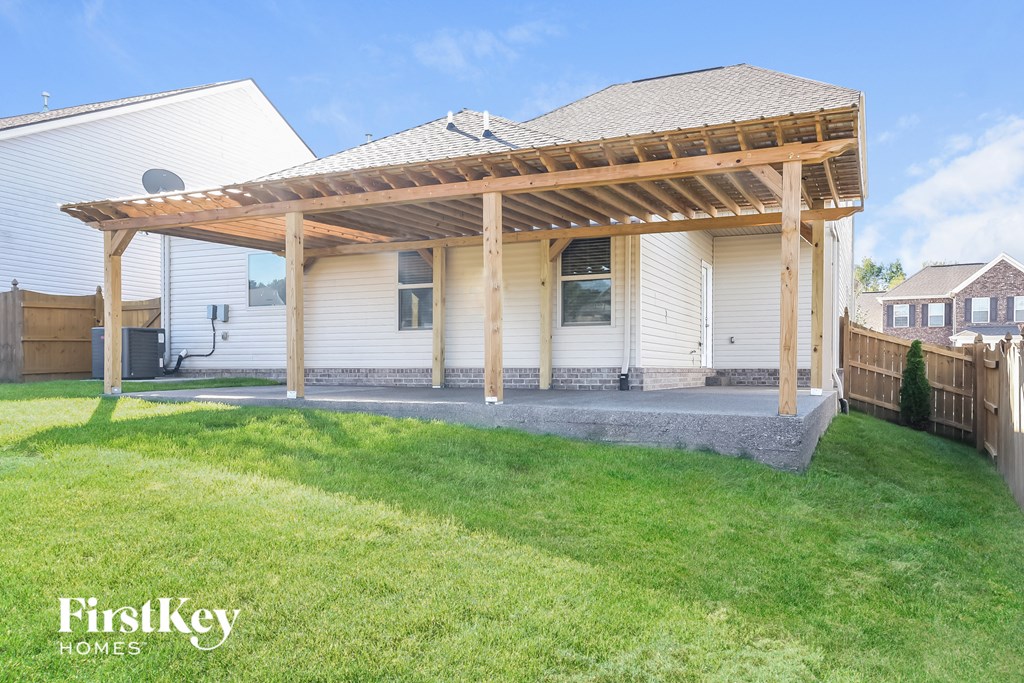 a white house with a porch with a wooden pergola