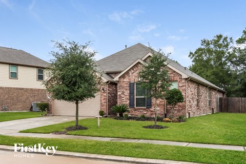 a house with a lawn and trees in front of it