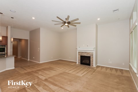 a living room with a fireplace and a ceiling fan