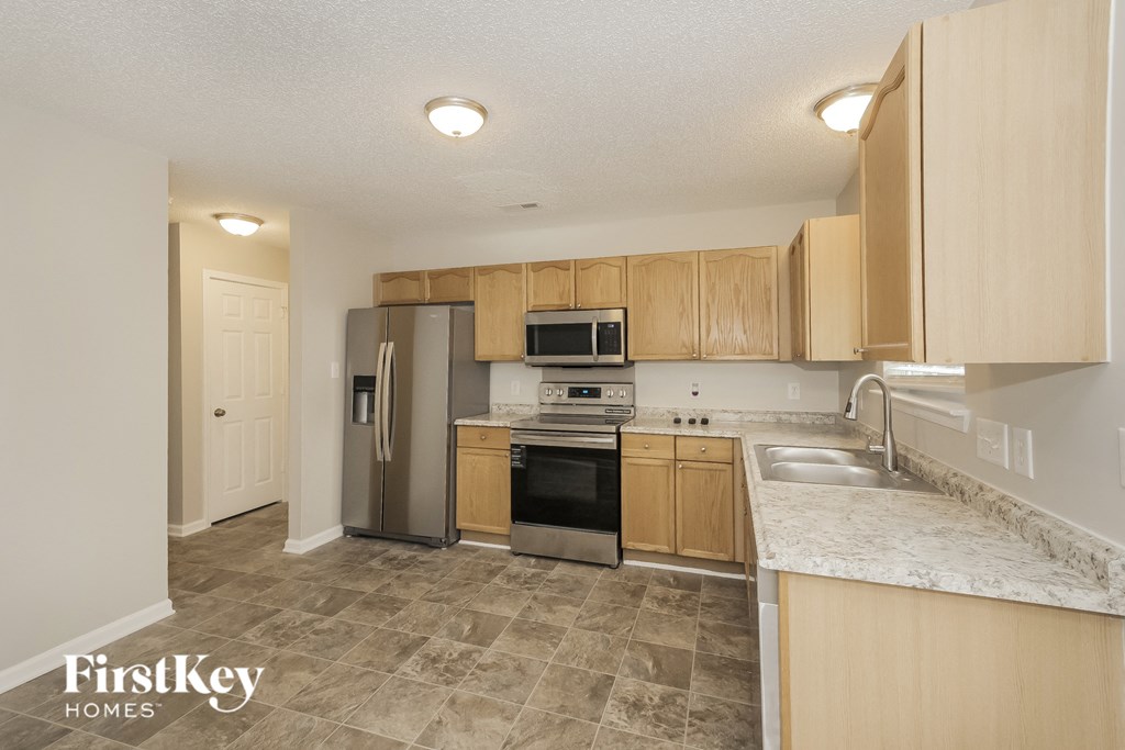 A kitchen with wooden cabinets and a marble countertop.