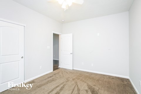 a bedroom with white walls and carpet and white doors