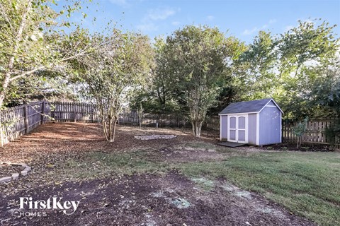 A backyard with a shed and trees.