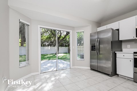 a kitchen with a stainless steel refrigerator and a door to a backyard