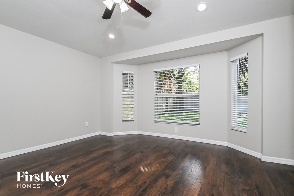 the living room with hardwood floors and a ceiling fan