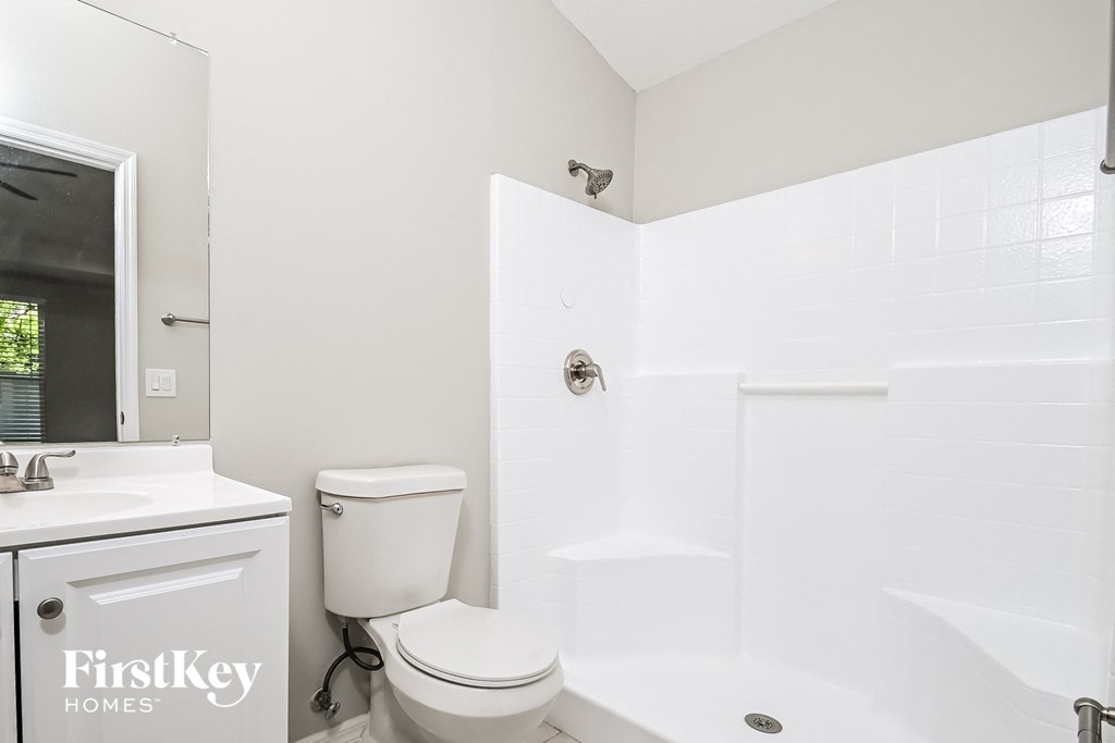 a white bathroom with a toilet and a tub and a sink