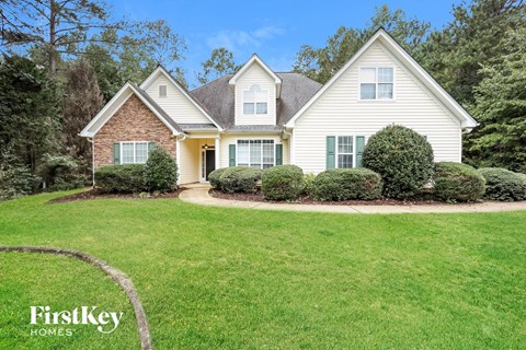 A house with a lawn and trees in the background.