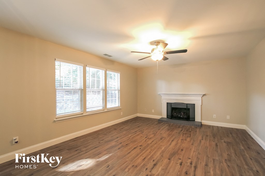 a living room with a fireplace and a ceiling fan
