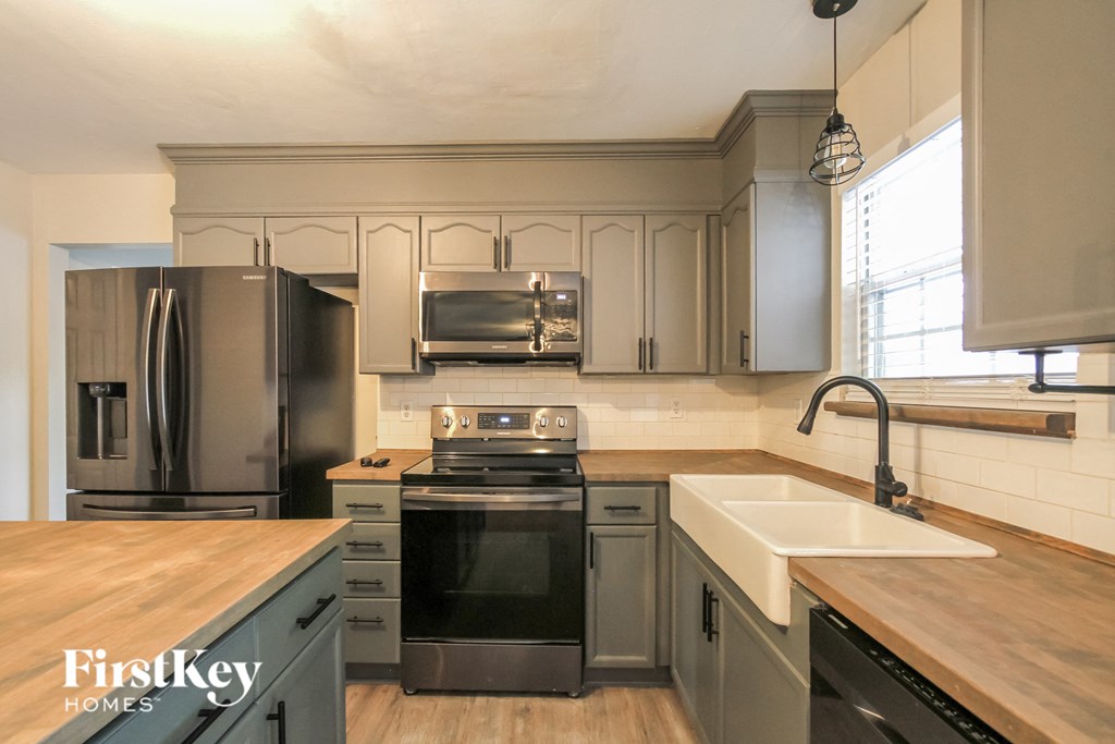 an updated kitchen with stainless steel appliances and wooden counter tops