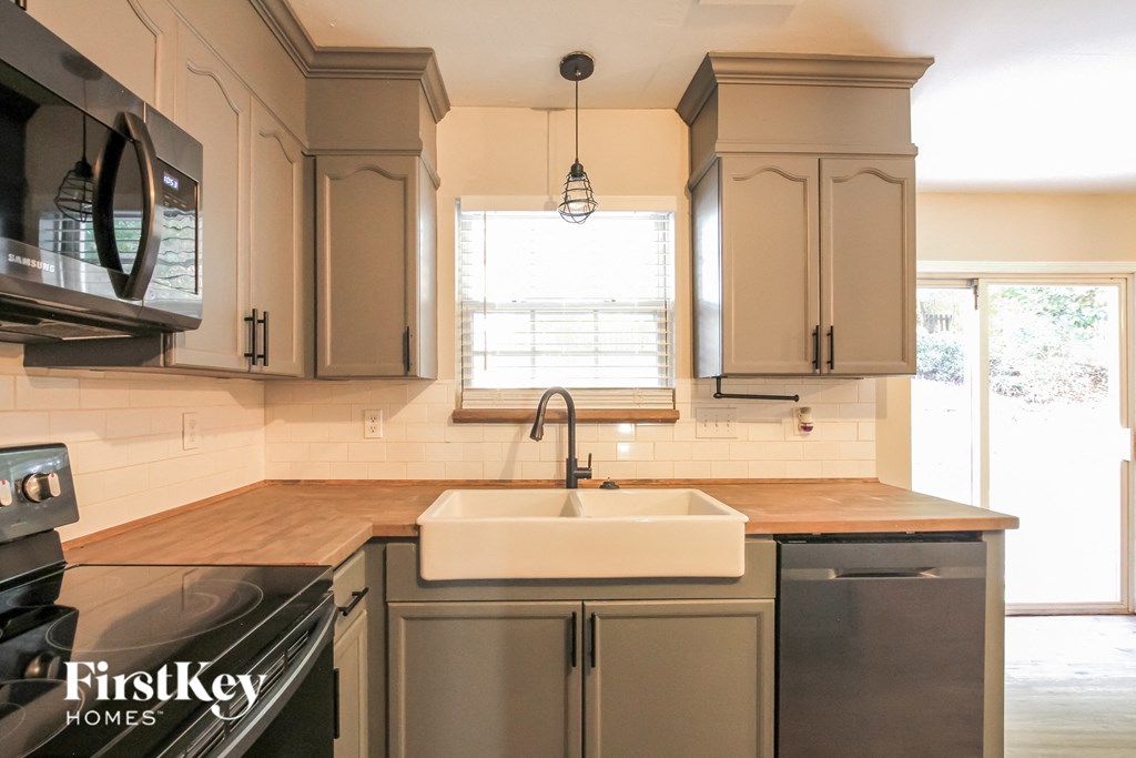 a kitchen with white cabinets and a sink and a window