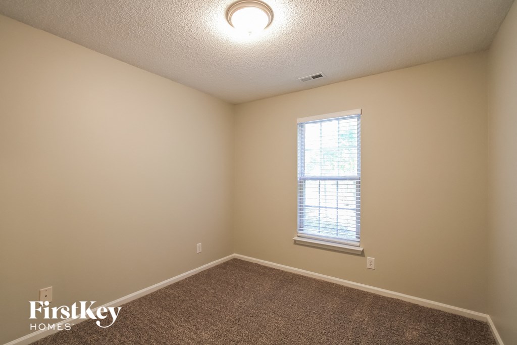 the upstairs bedroom with carpet and a window