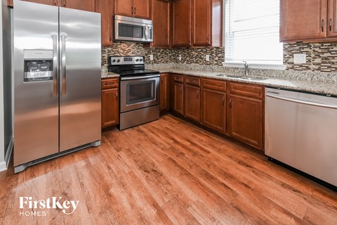 A kitchen with wooden cabinets and a stainless steel refrigerator.