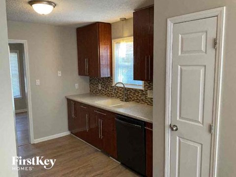 A kitchen with brown cabinets and a white door.