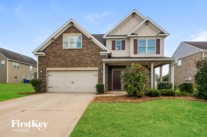 A house with a garage and a driveway in front of it.