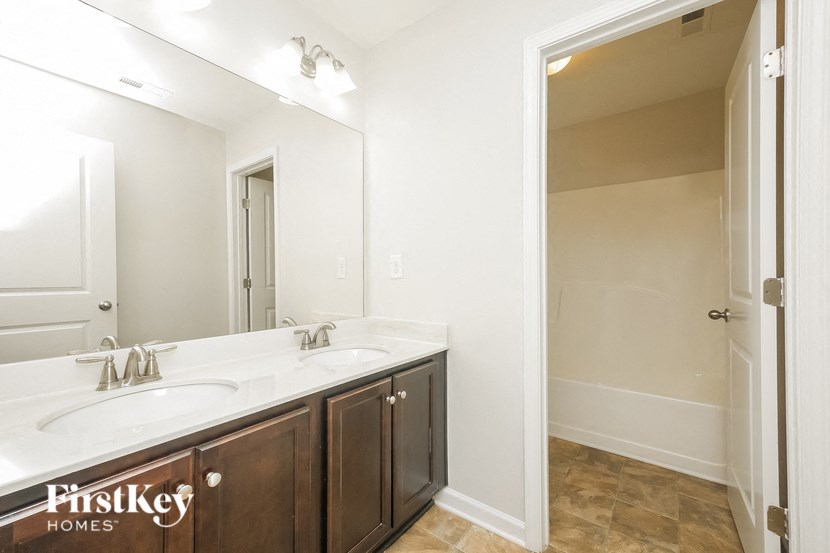 A bathroom with a double sink vanity and a large mirror.