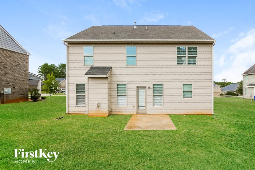 A house with a brown roof and a white wall with a window and a door.
