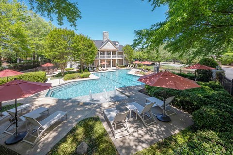 A large house with a pool and patio furniture.